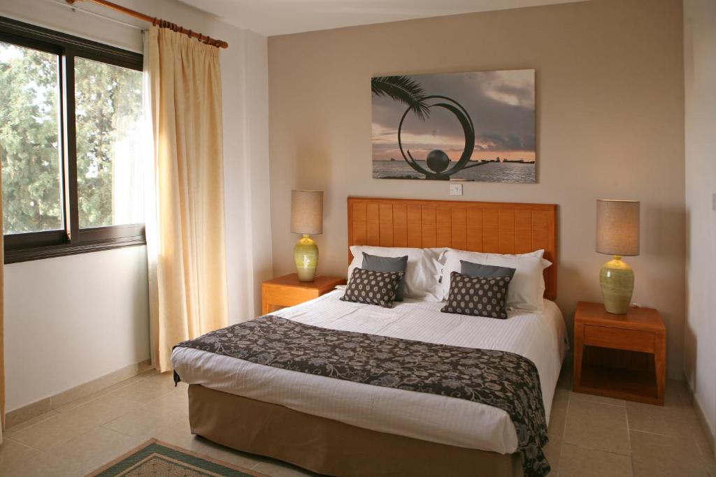 a bedroom with a large bed and a large window at Club Aphrodite in Erimi