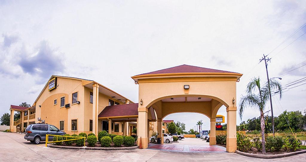 un edificio con un arco frente a un aparcamiento en Downtowner Inn and Suites - Houston, en Houston