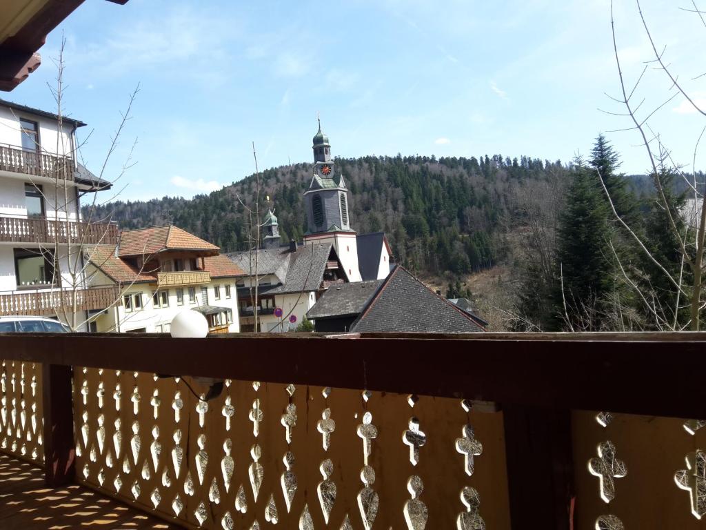 a balcony with a view of a town with a lighthouse at Antico Mulino Pension & Ristorante Todtmoos in Todtmoos