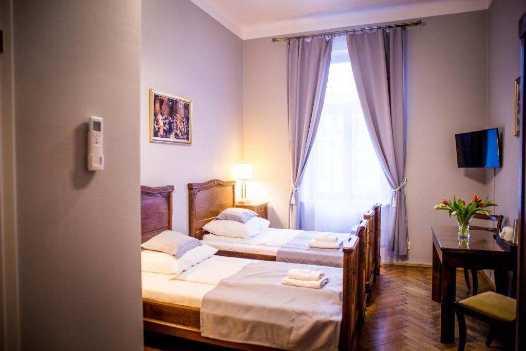 2 camas en una habitación de hotel con ventana en Aparthotel Maria, en Cracovia