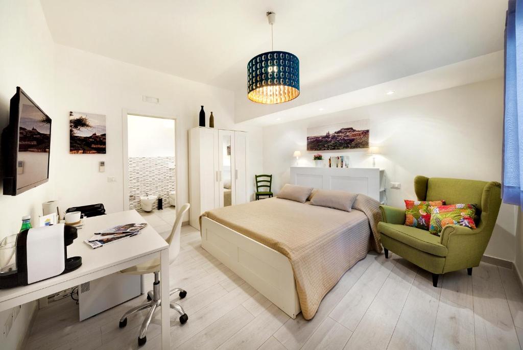1 dormitorio con cama, escritorio y silla en siciliacasevacanze - Marina Domus Rooms, en Marina di Ragusa