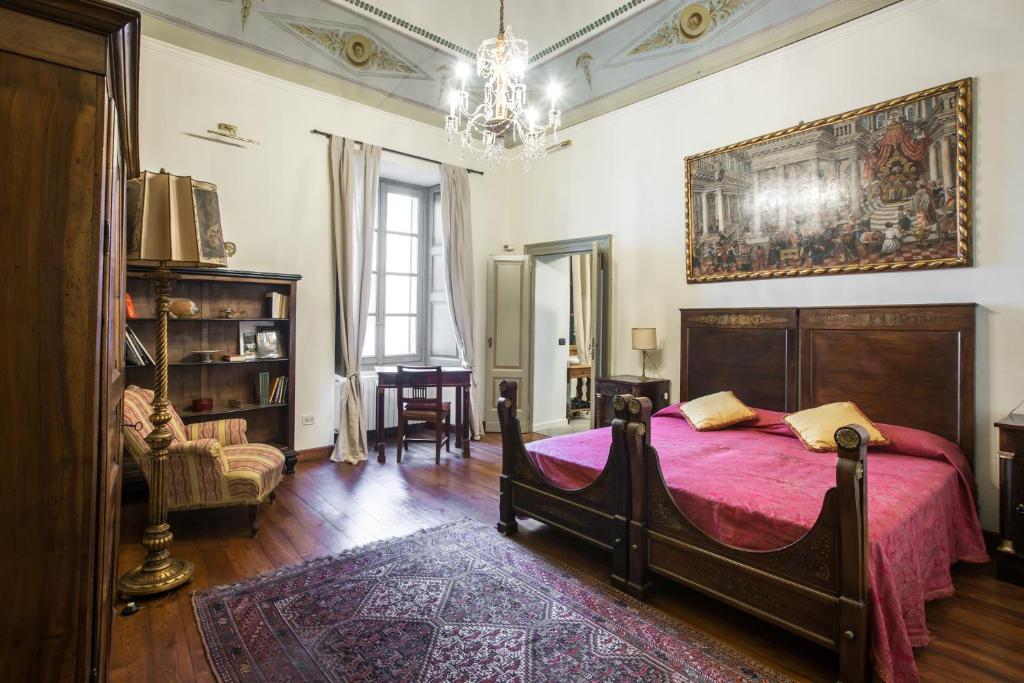 - une chambre avec un grand lit et une couverture rose dans l'établissement Palazzo Salis - La Dimora del Conte, à Tirano
