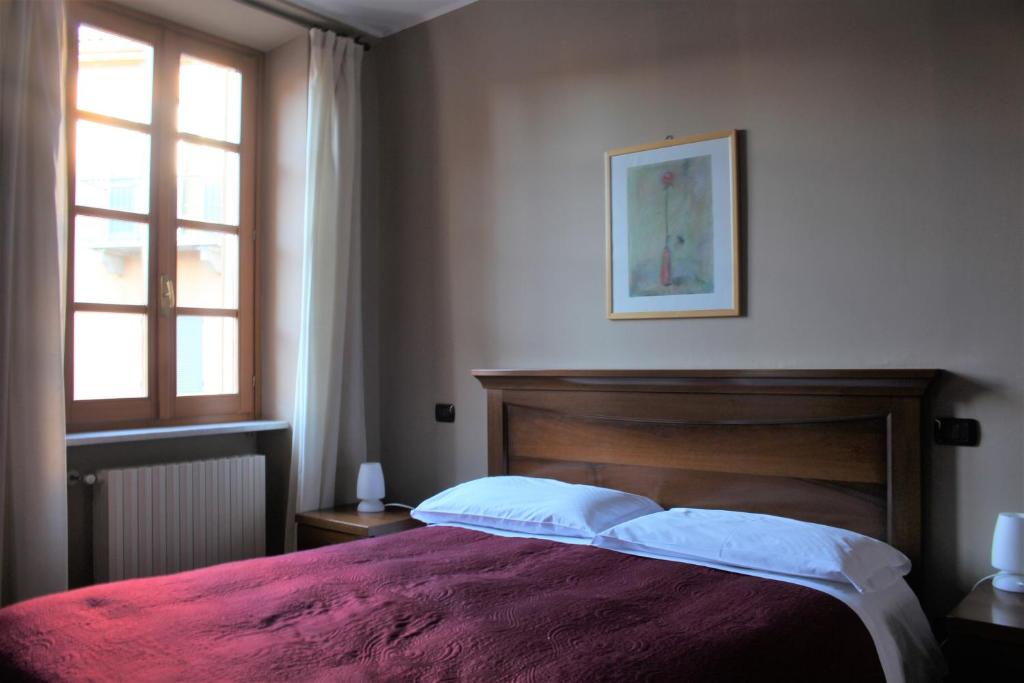 um quarto com uma cama e uma janela em Albergo San Lorenzo em Alba