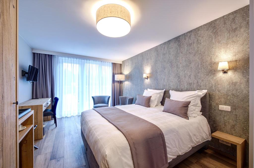 una camera d'albergo con un grande letto e una scrivania di Au fil de l'eau a Seneffe