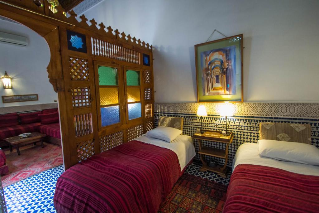 a hotel room with two beds and a couch at Riad Dar Cordoba in Fès