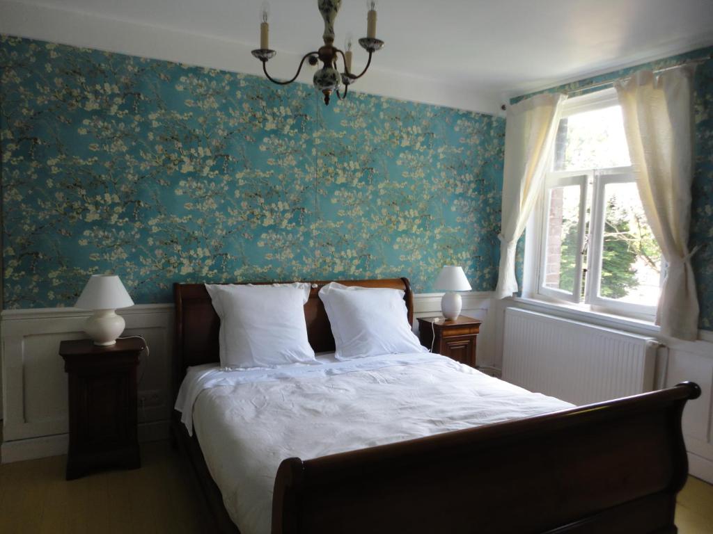 um quarto com uma cama com papel de parede floral verde em Villa Tournesol em Tournai