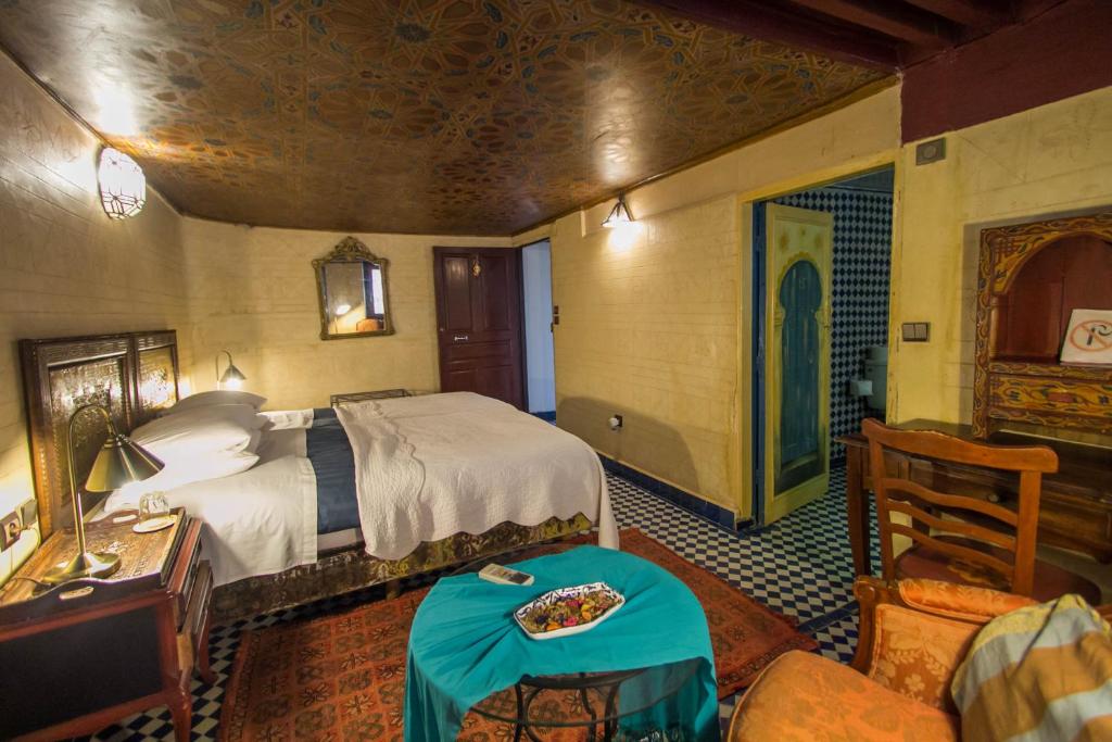 a bedroom with a bed and a table in a room at Riad Dar Cordoba in Fès
