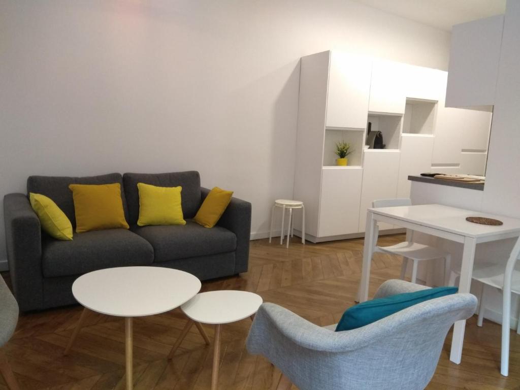 a living room with a couch and two tables at Mercière Jacobins in Lyon