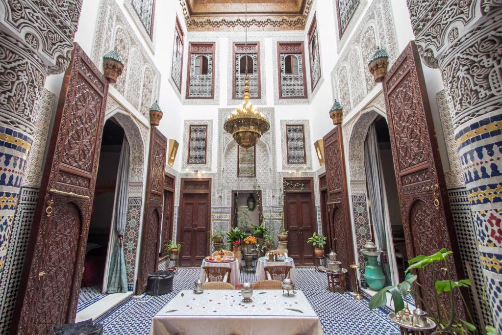 a hallway in a mosque with a table and chairs at Riad Dar Cordoba in Fès