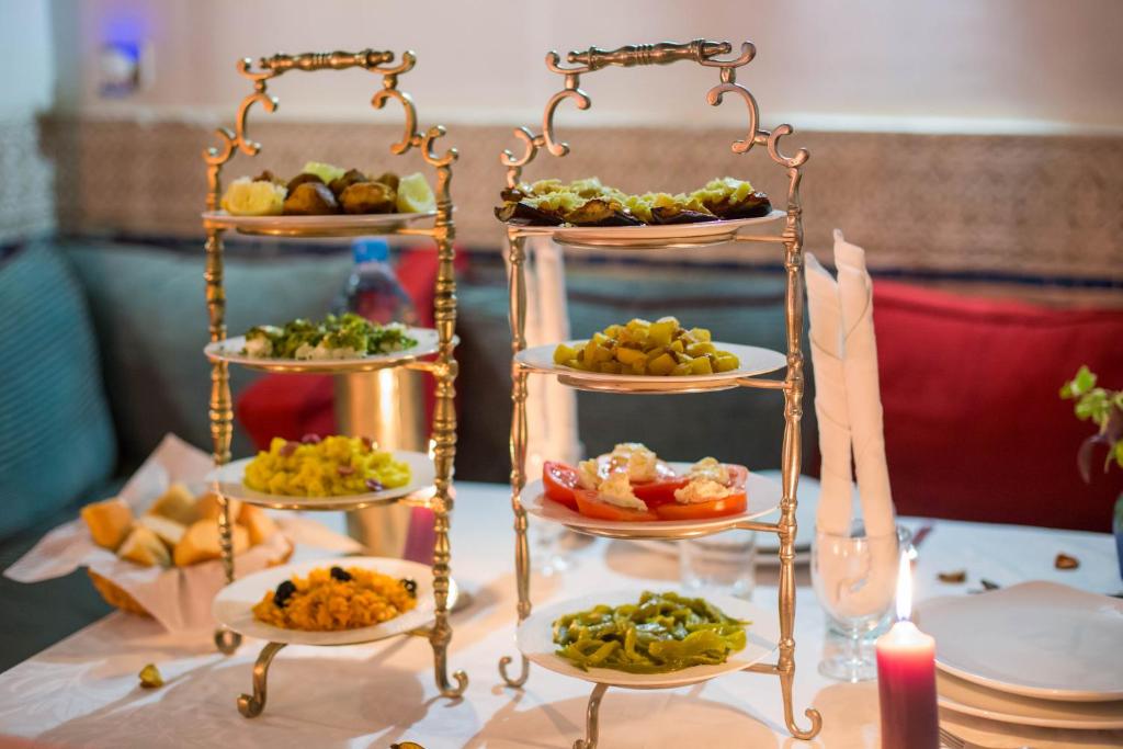 a table topped with three tiered plates of food at Riad Dar Cordoba in Fès