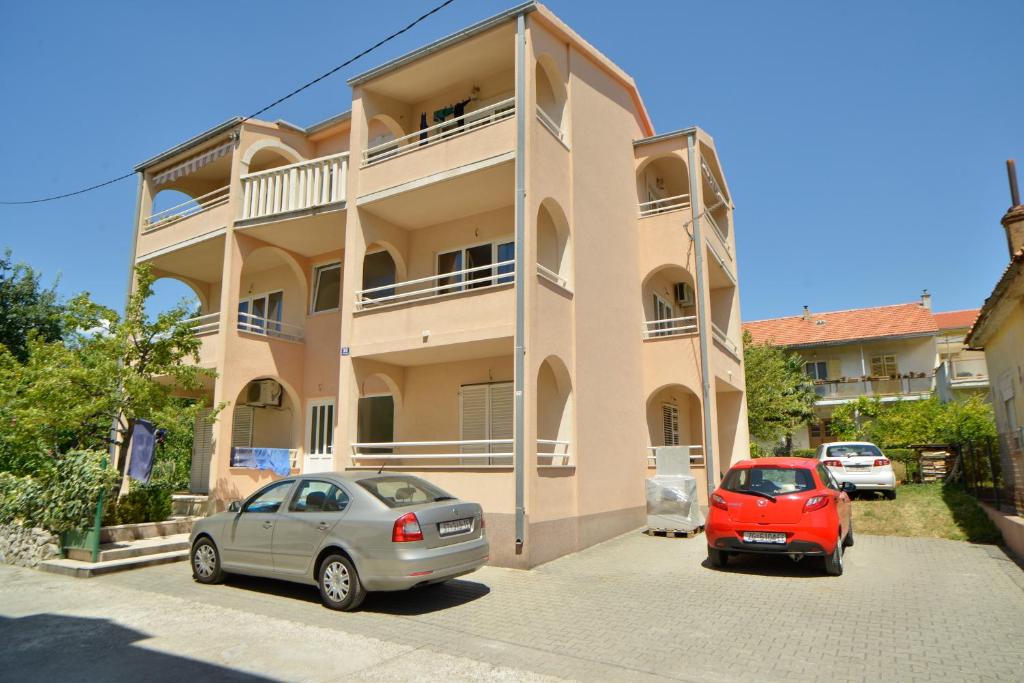 two cars parked in front of a building at Barać in Kaštela