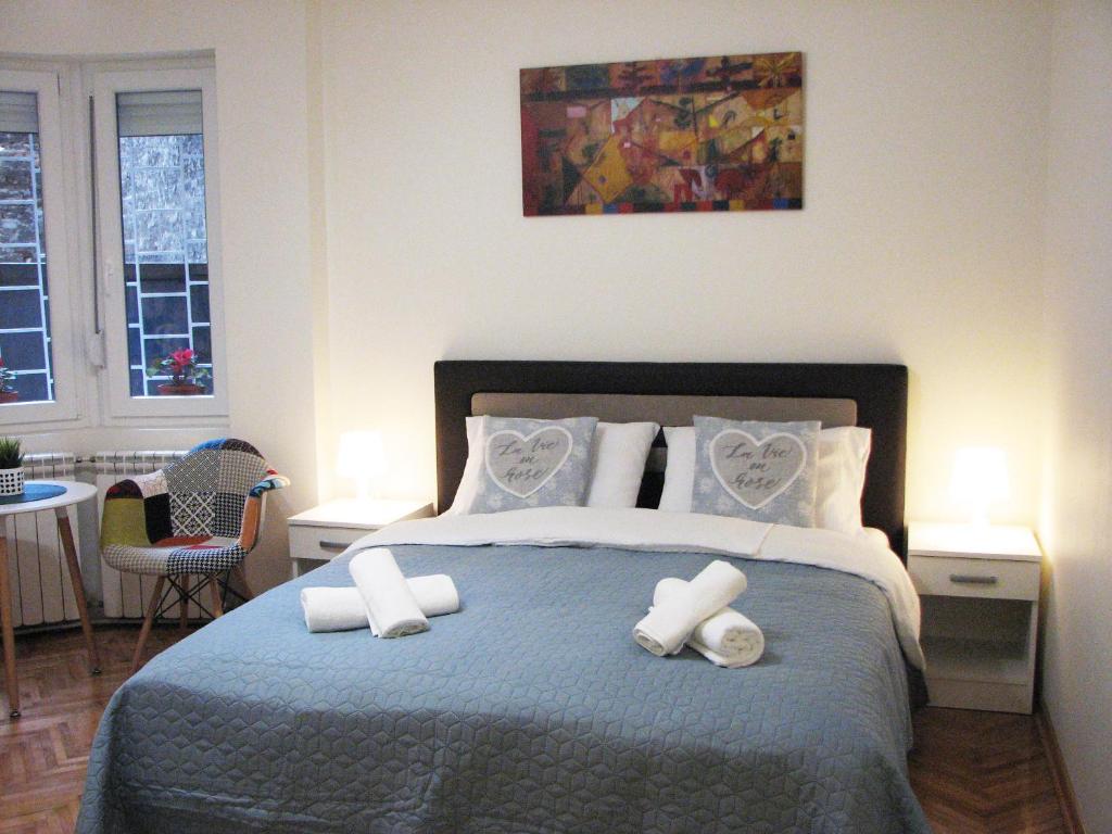 a bedroom with a bed with two hearts pillows at Bohemian Dawn Apartment in Belgrade