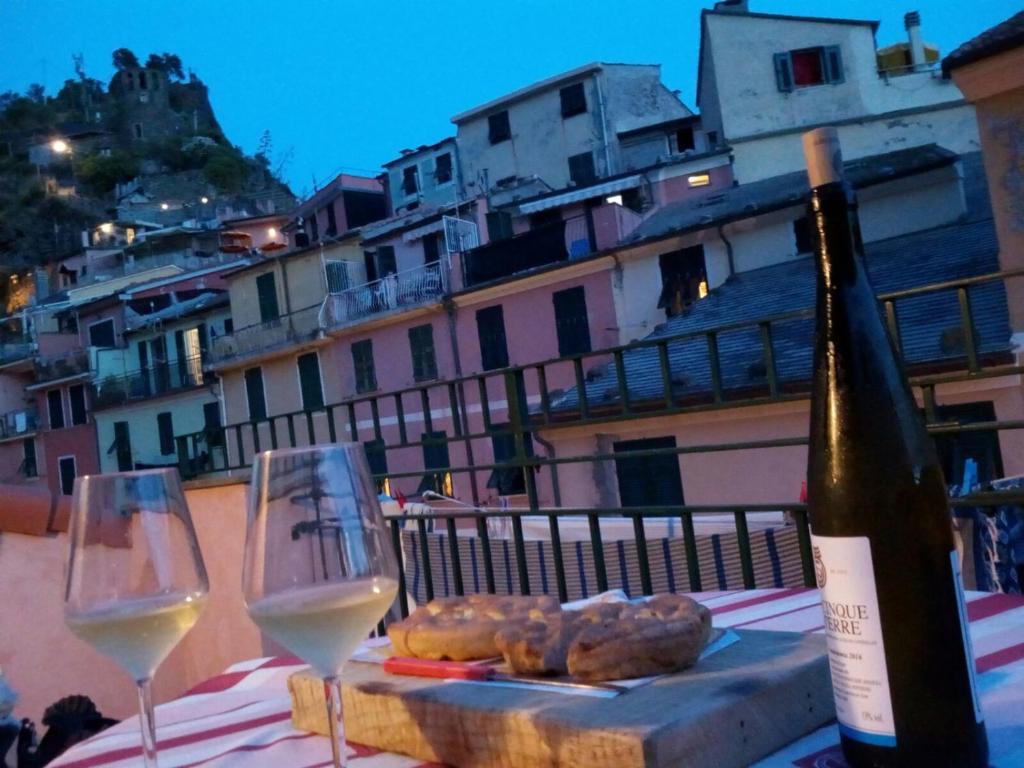 a bottle of wine and two wine glasses on a table at The Terrace in Vernazza