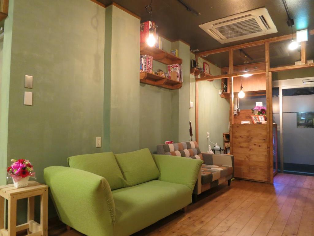 東京にあるノーボーダーズ ホステルのリビングルーム(緑のソファ付)
