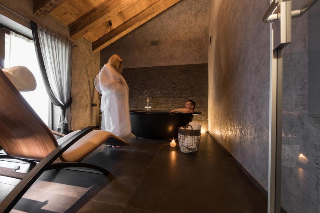 mężczyzna stojący w łazience z wanną w obiekcie Relais Bondaz w Aoście