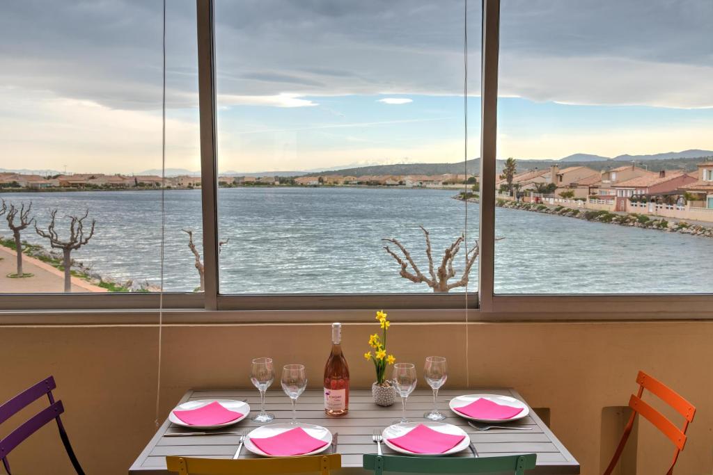 een tafel met uitzicht op het water bij Appartement Le Flamant Rose in Port-la-Nouvelle