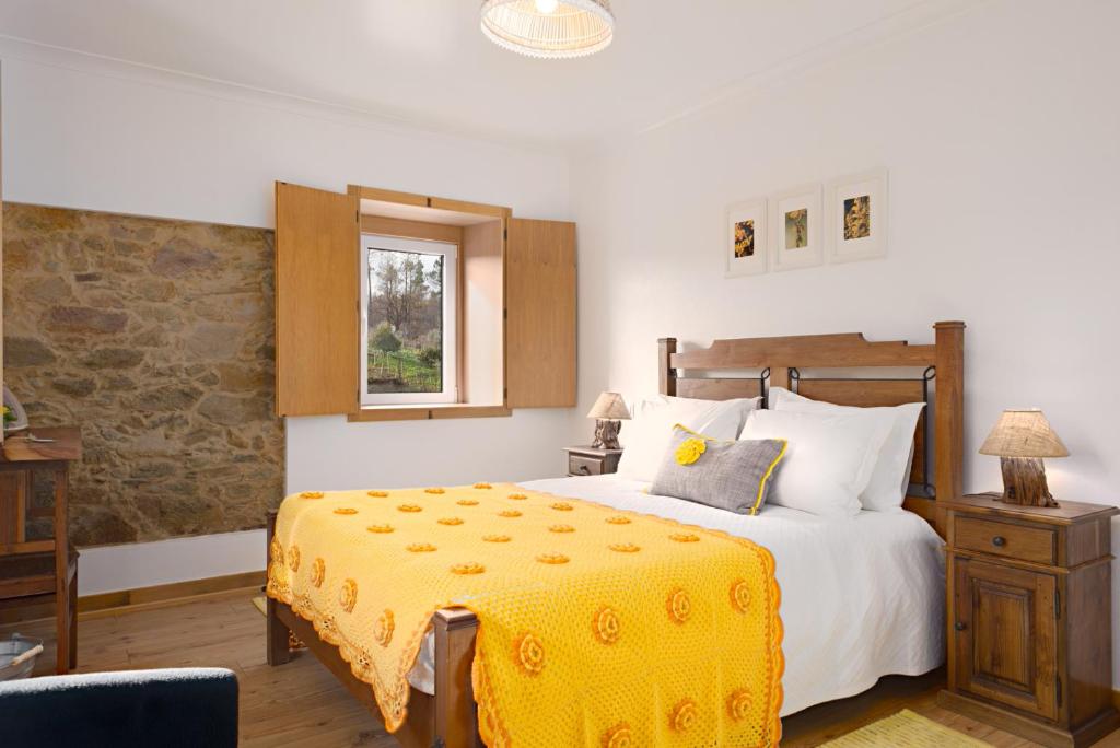 a bedroom with a large bed with a yellow blanket at Casa De Santo Antão - Turismo Rural in Padrões