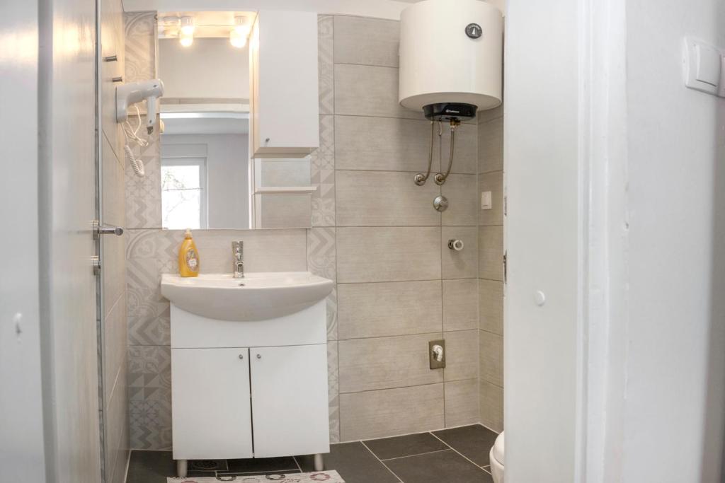 a white bathroom with a sink and a shower at Una La Unica in Bihać