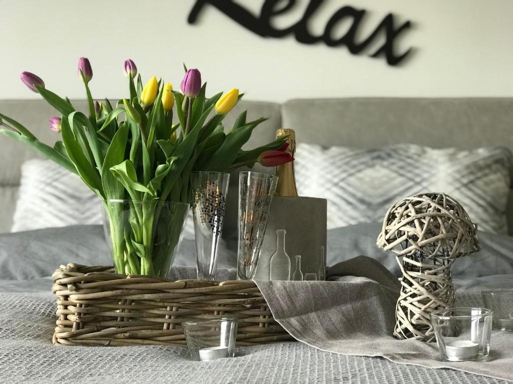 a table with a basket of flowers on a bed at Ferienwohnung Weserblick-Hameln in Hameln