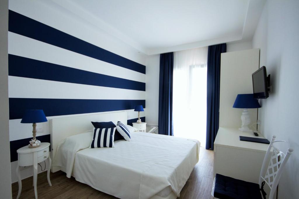 a bedroom with a blue and white striped wall at Hotel Nautilus in Cagliari