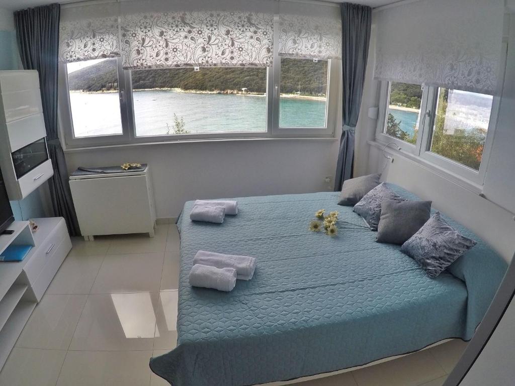 a bedroom with a blue bed with two teddy bears on it at Studio apartment More in Rabac