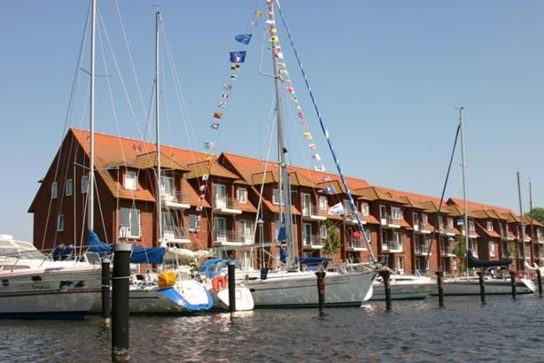 ウッカーミュンデにあるLagunenstadt Ueckermünde AGの建物前に停泊する帆船