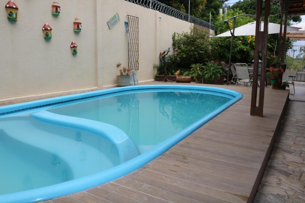 a blue swimming pool next to a building at Pousada Flor Dália in Natal
