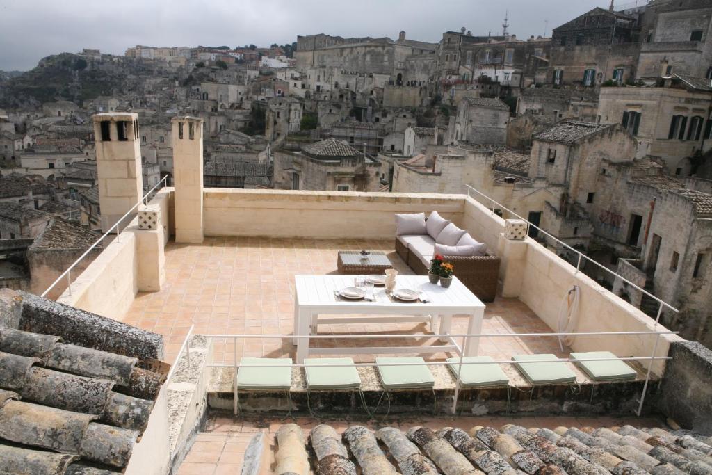 a balcony with a table and a view of a city at Le Tre Vie Apartment & Room in Matera