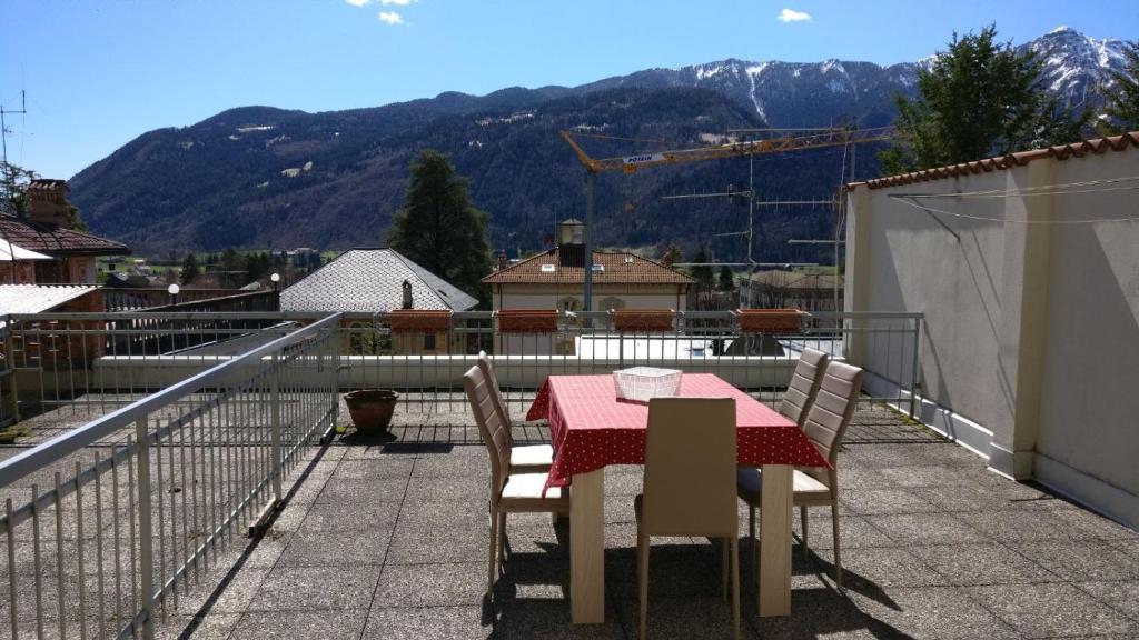 un tavolo e sedie su un balcone con vista sulle montagne di Nuovo appartamento a Clusone a Clusone