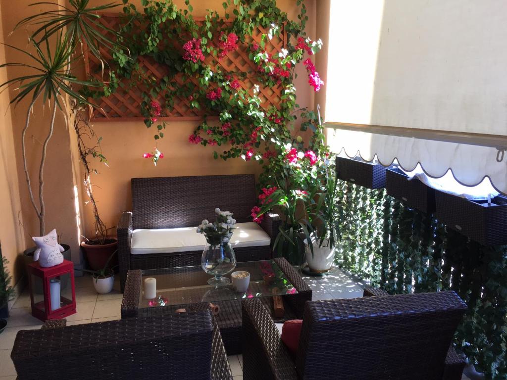 un patio con un banco con flores y plantas en Flowers Apartment, en Bari
