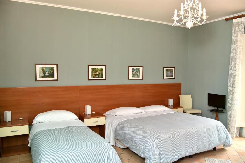 una camera con due letti e un lampadario a braccio di Affittacamere Sestiere Santa Caterina a Grammichele