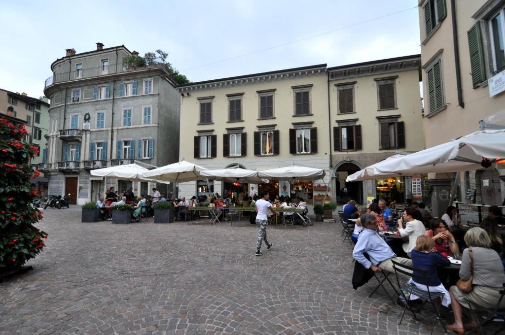 a group of people sitting at tables in a courtyard at Antico Ducato in Bergamo
