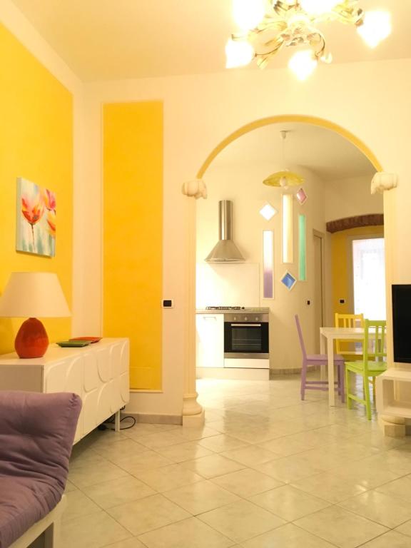 sala de estar con paredes amarillas y cocina en 15 Piazza Saint Bon, en La Spezia