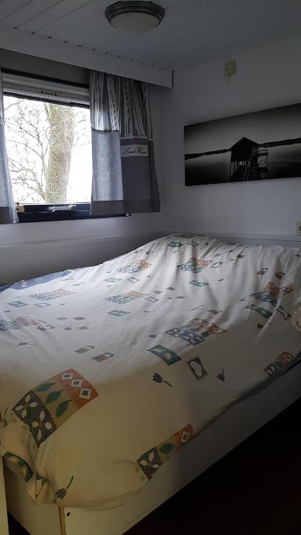 a bedroom with a bed with a comforter on it at Corona Laboris in Colijnsplaat