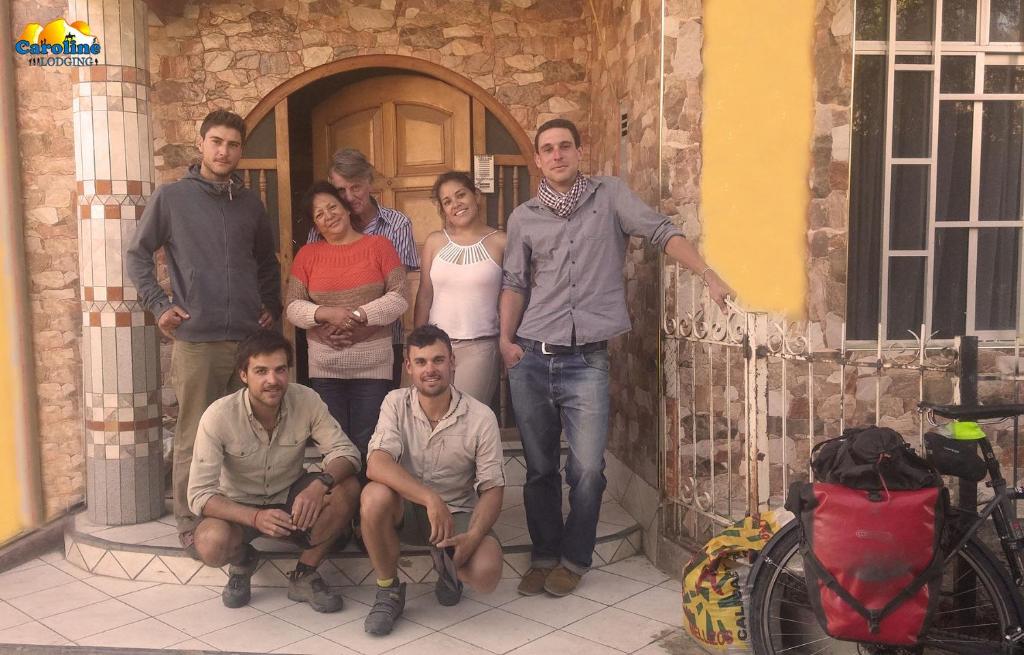 a group of people posing for a picture in front of a building at Caroline lodging in Huaraz