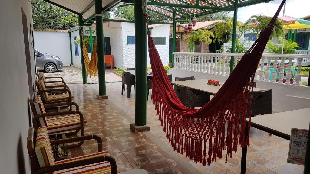 a hammock on a patio with a table and chairs at Villa Apolonia in Guaduas