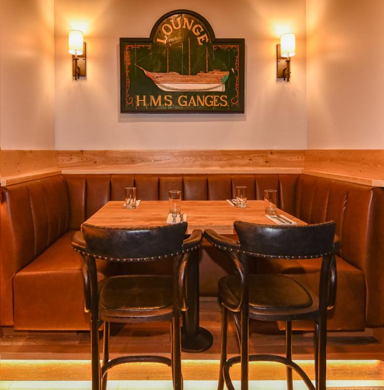 a restaurant with a wooden table and chairs at Harbour House Hotel in Ganges