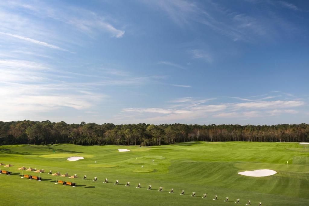 a green golf course with two putting greens and trees at Four Seasons Resort Orlando at Walt Disney World Resort in Orlando