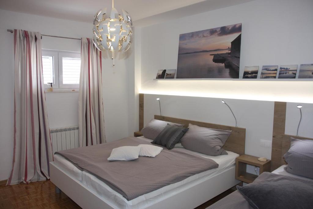 ein Bett mit zwei Kissen darauf in einem Schlafzimmer in der Unterkunft Apartments Villa Agatha in Sveti Filip i Jakov