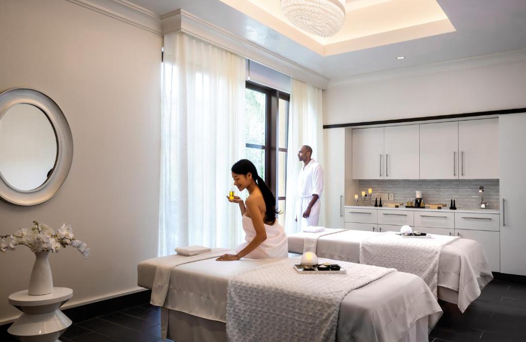 a woman sitting on two beds in a hotel room at Four Seasons Resort Orlando at Walt Disney World Resort in Orlando