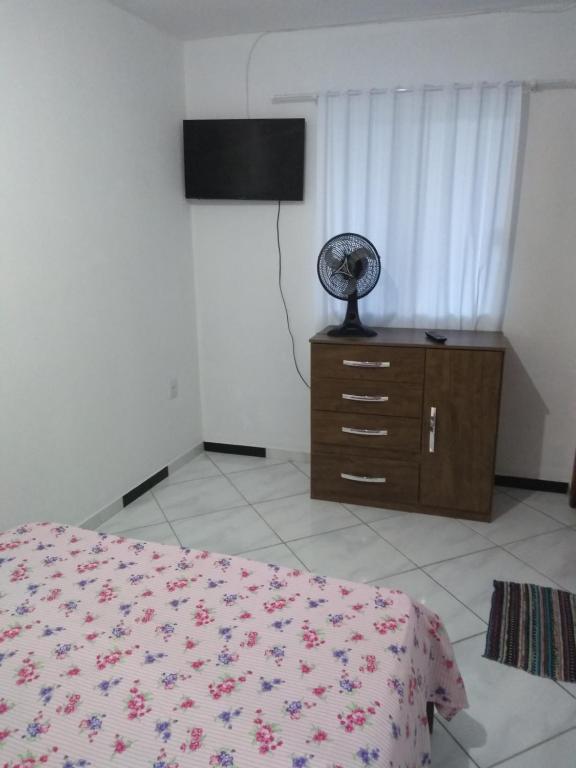 1 dormitorio con 1 cama y vestidor con ventilador en Pousada Pingo de Ouro, en Florianópolis