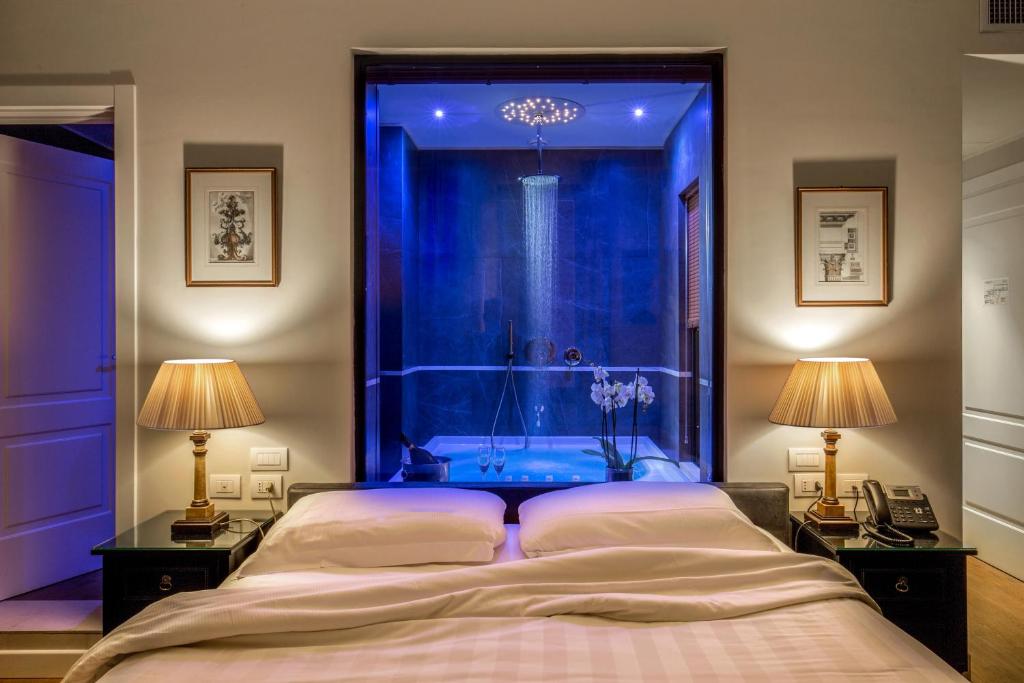 a bedroom with a blue room with a bed and two lamps at Hotel Monte Cenci in Rome