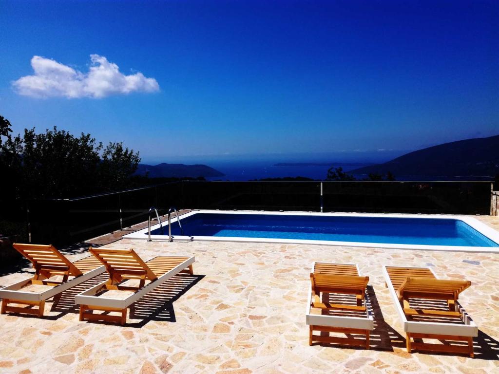 een groep stoelen naast een zwembad bij Vila Bella Vista in Herceg-Novi
