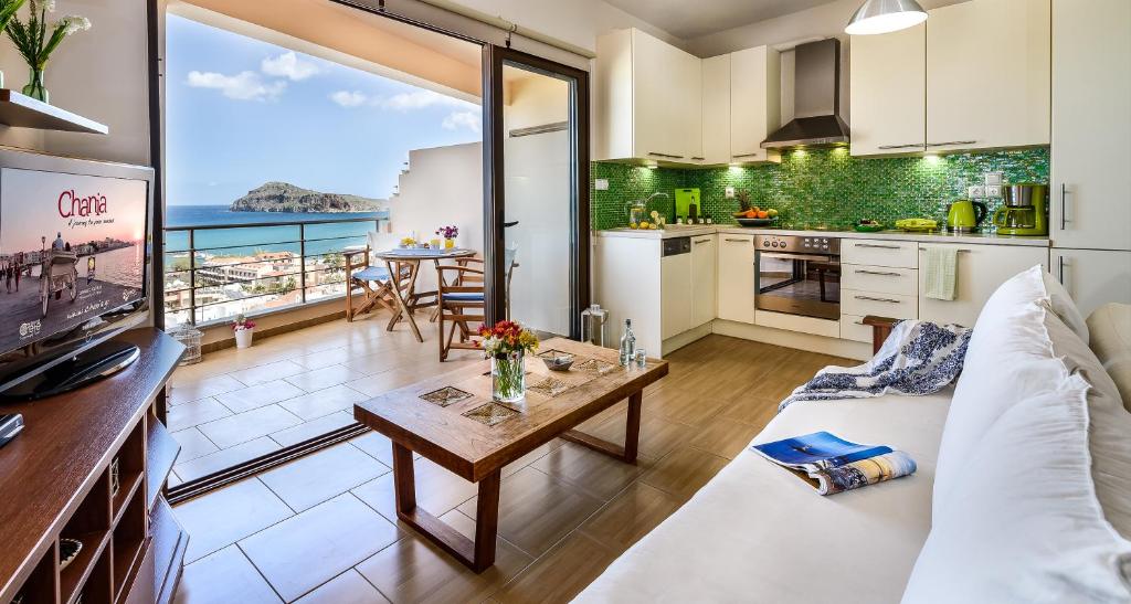 a kitchen and living room with a view of the ocean at Platanias Sky View in Plataniás