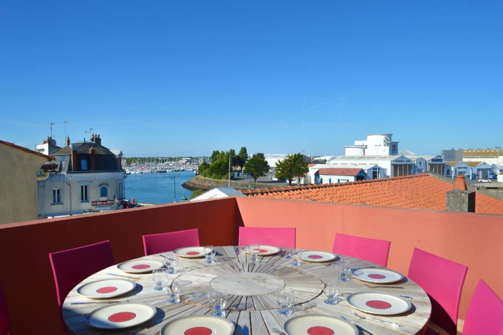 een tafel op een balkon met uitzicht op het water bij Villa du Quai in Les Sables-dʼOlonne