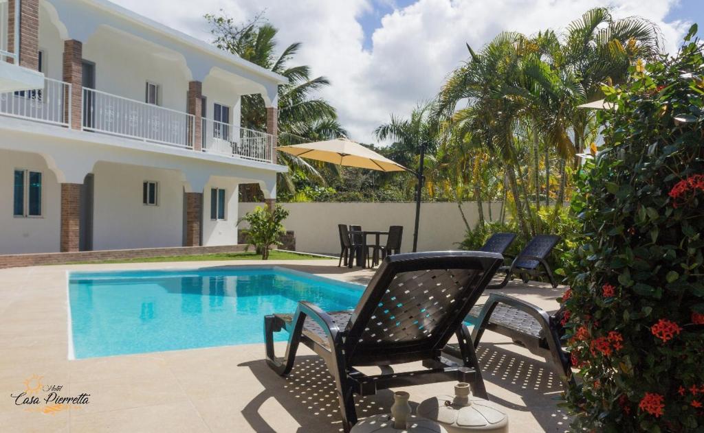 a villa with a swimming pool in front of a house at Hotel Casa Pierretta in Las Terrenas