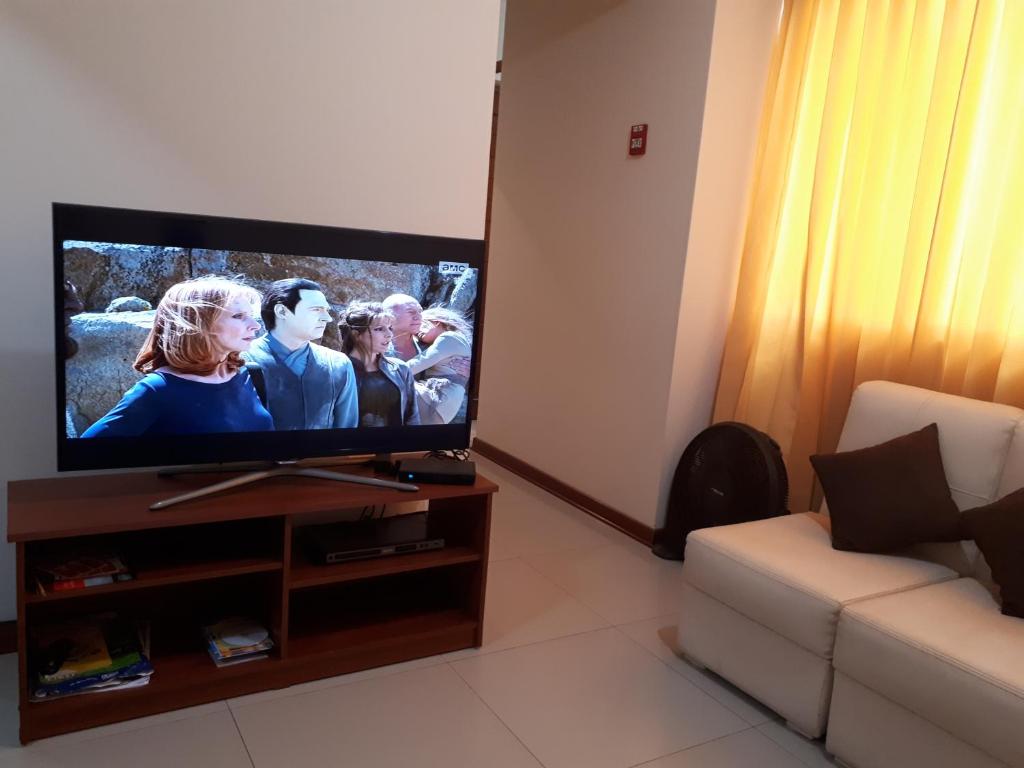 TV de pantalla plana en la sala de estar con sofá en Departamento Familiar En Chiclayo, en Chiclayo