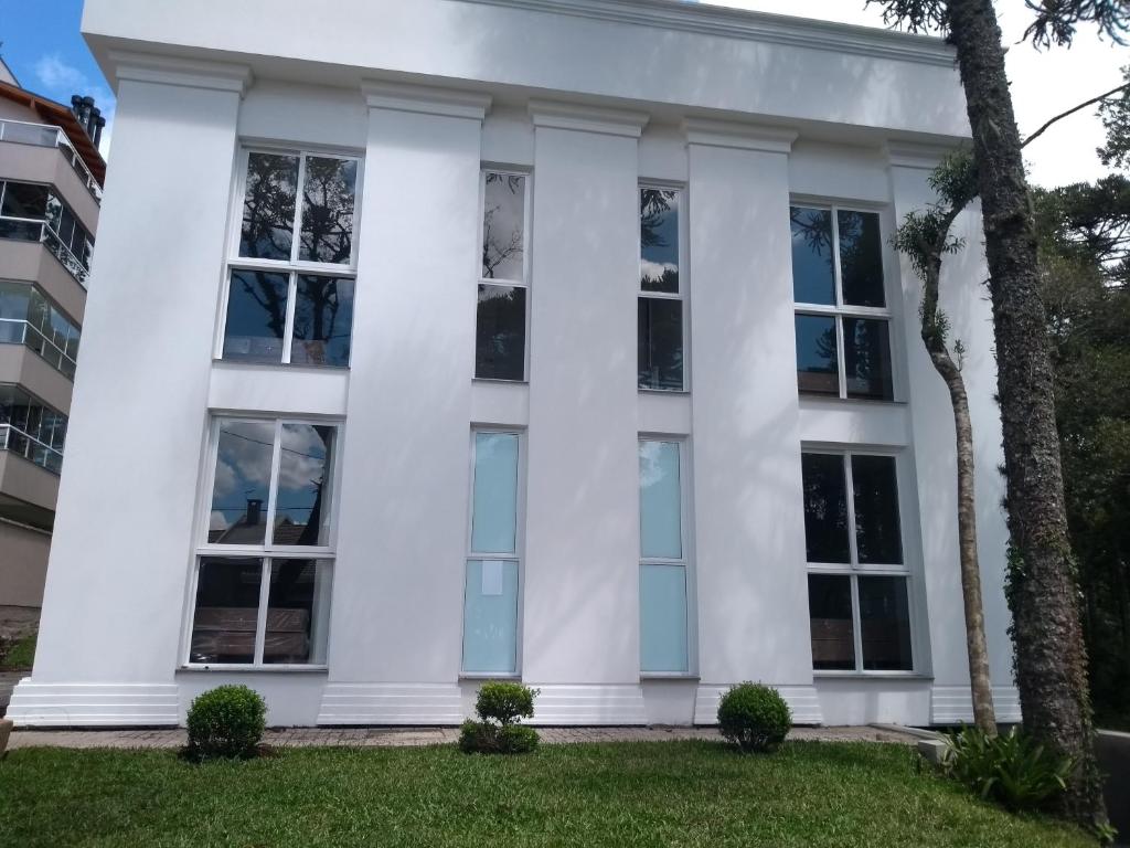 Casa blanca con ventanas grandes en Piavi Residencial, en São Francisco de Paula