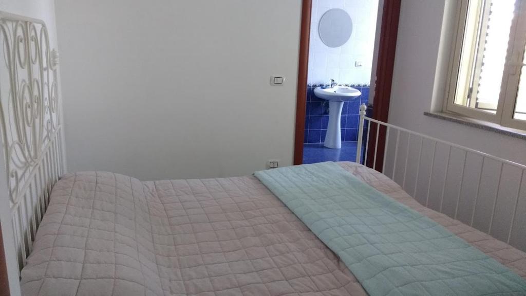 1 dormitorio con 1 cama y lavamanos en una habitación en Vista Montagna, en Caulonia Marina