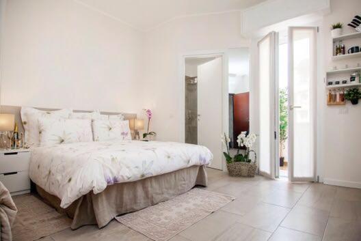 um quarto branco com uma cama grande e lençóis brancos em Appartamento Via Acquati 12 - Monolocale 1 em Cormano